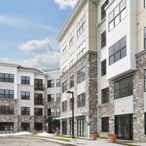 Exterior of modern apartment building with stone facade and large windows in winter setting