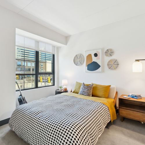 Apartment bedroom with carpeting and windows
