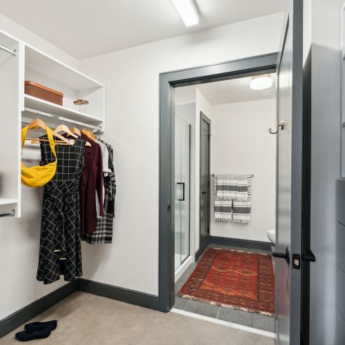 Large walk-in closet with storage that leads to bathroom