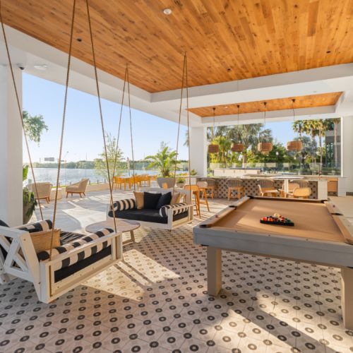 NOVEL Beach Park poolside club area with seating and pool table