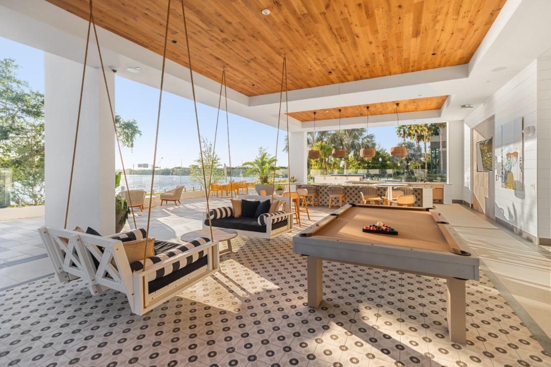 NOVEL Beach Park poolside club area with seating and pool table