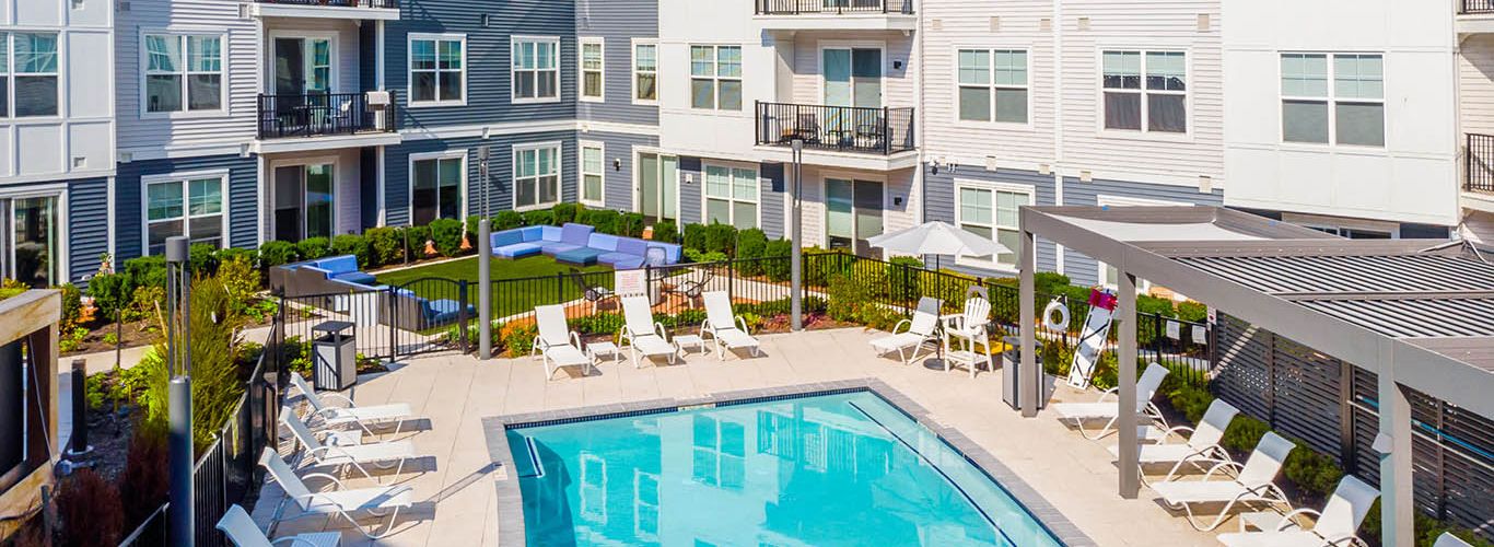 View of pool, grass, and apartments