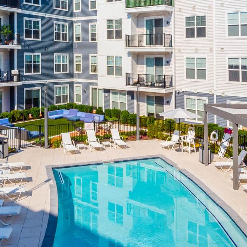 View of pool, grass, and apartments