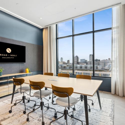 Conference room with table, TV and city views	