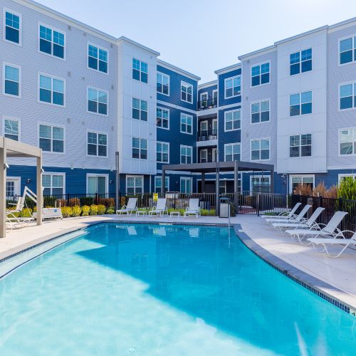Pool with lounge chairs and view of apartments	
