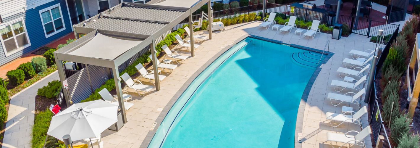 Pool with lounge chairs and view of apartments	