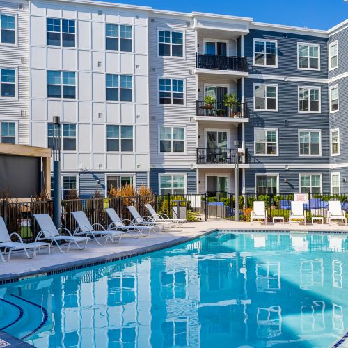 Pool with lounge chairs and view of apartments	