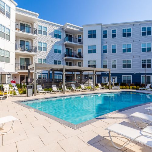 Pool with lounge chairs and view of apartments	