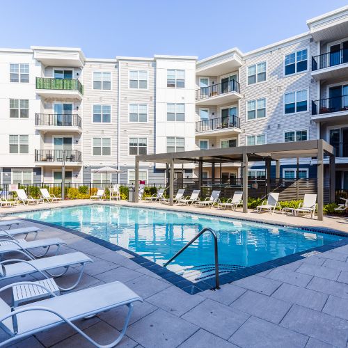 Pool with lounge chairs and view of apartments	