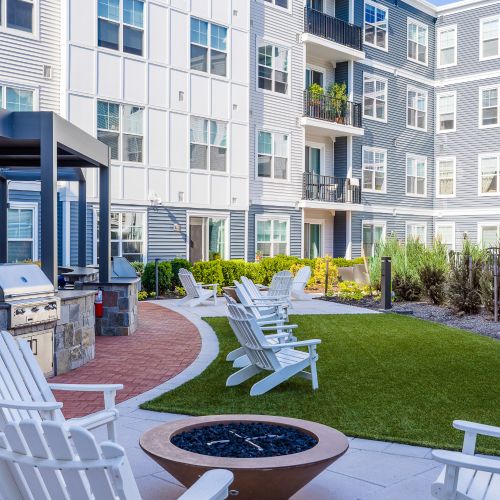 View of courtyard firepit, grills, screening, and lounge chairs	