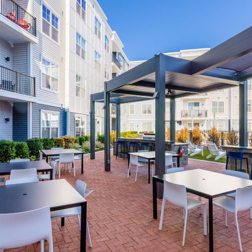 Outdoor dining with view of screen and apartments	