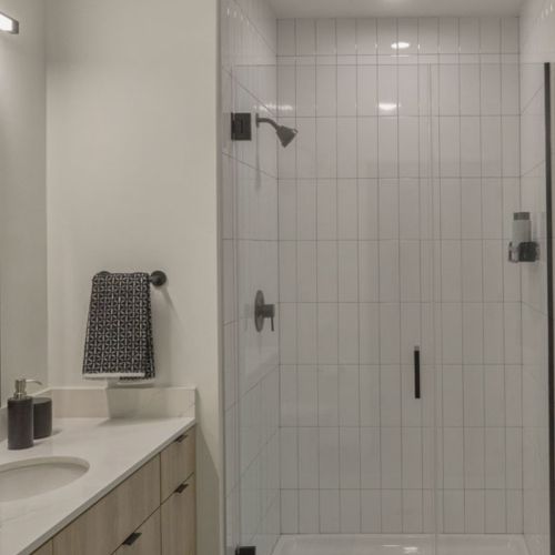 Bathrooms with expansive vanity space and showers with subway tile	