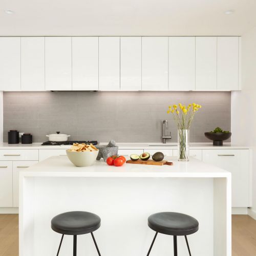 Kitchen showing island and all white cabinetry 