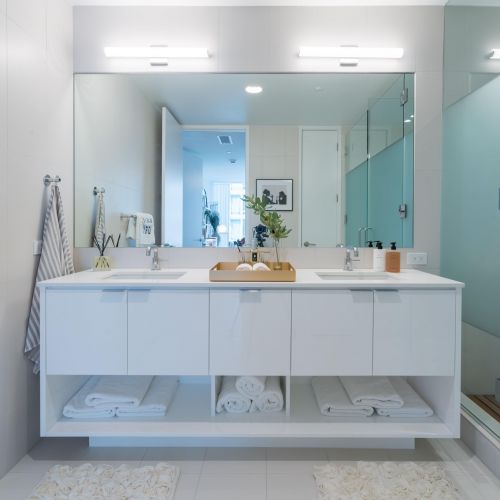 Bathroom with large mirror, counter space, and standing shower