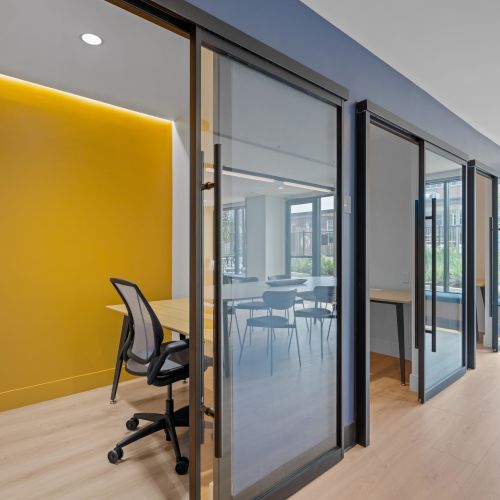 Lounge with work pods and communal table.	