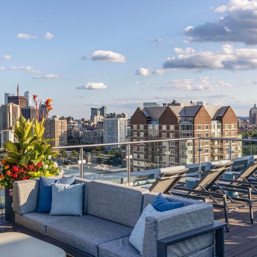 Rooftop deck lounge seating with city view.