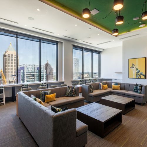 Lounge with sectional sofas, skyline views, green ceiling, and modern lighting fixtures	