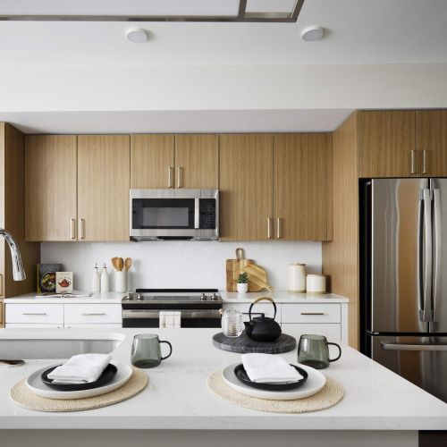 Oakville : With two-tone kitchen cabinets in wood grain and white with hexagonal white tile backsplash	
