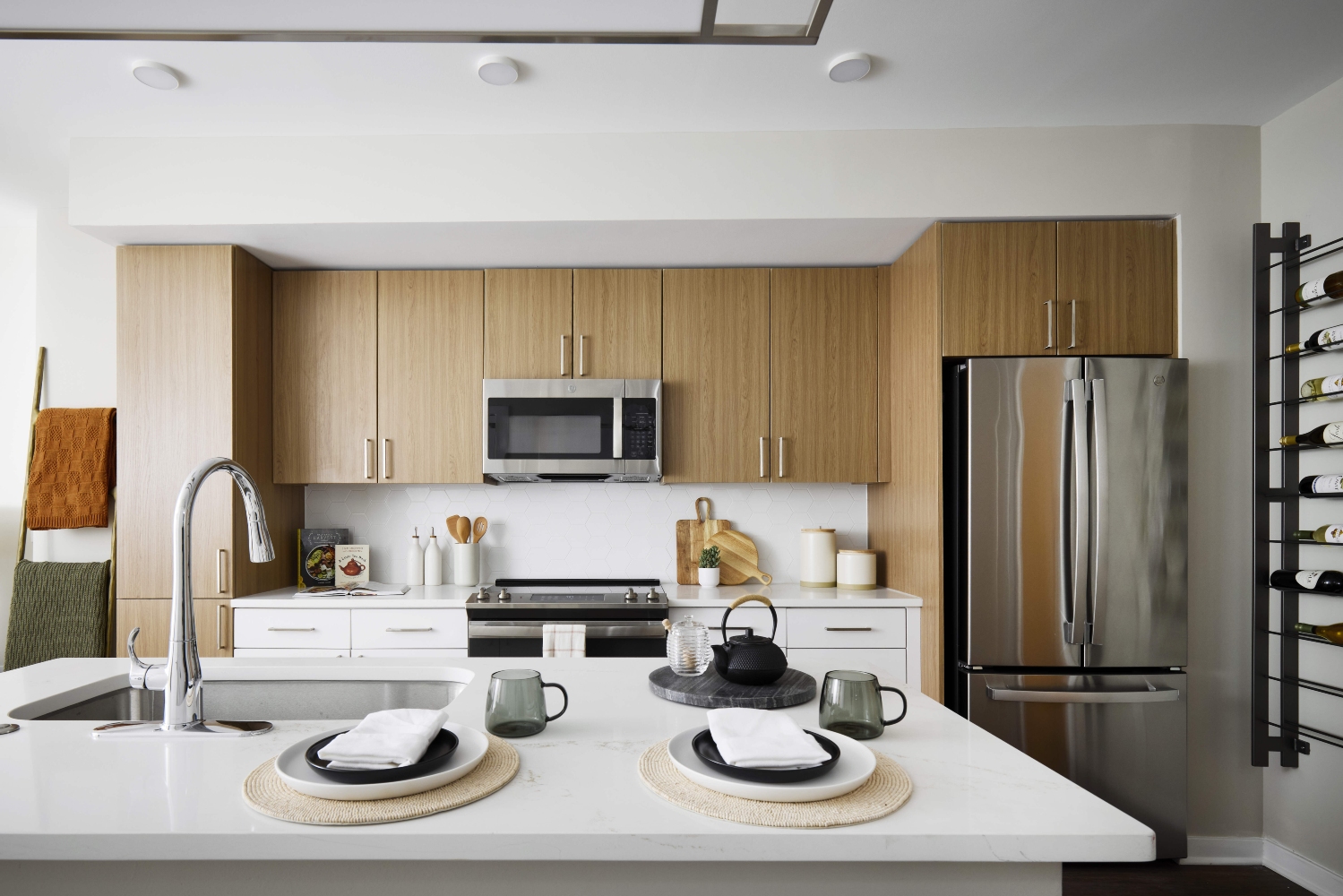 Oakville : With two-tone kitchen cabinets in wood grain and white with hexagonal white tile backsplash	