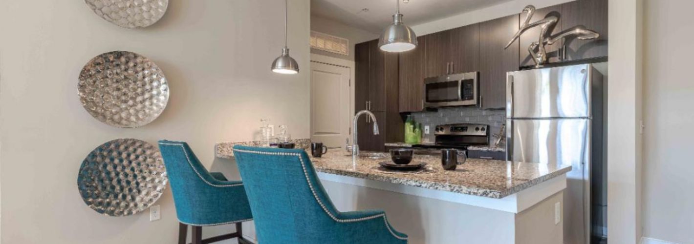 Photo of kitchen with stainless steel appliances and  two barstools