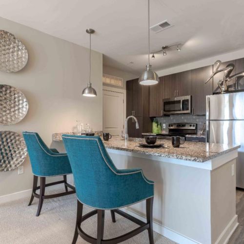 Photo of kitchen with stainless steel appliances and  two barstools