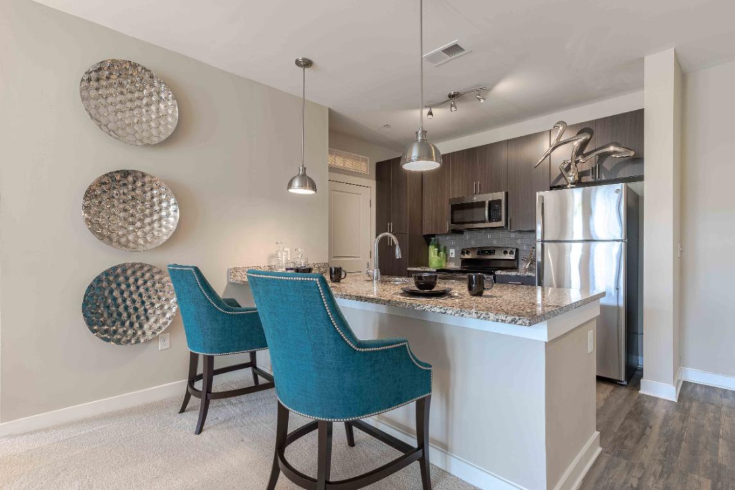 Photo of kitchen with stainless steel appliances and  two barstools