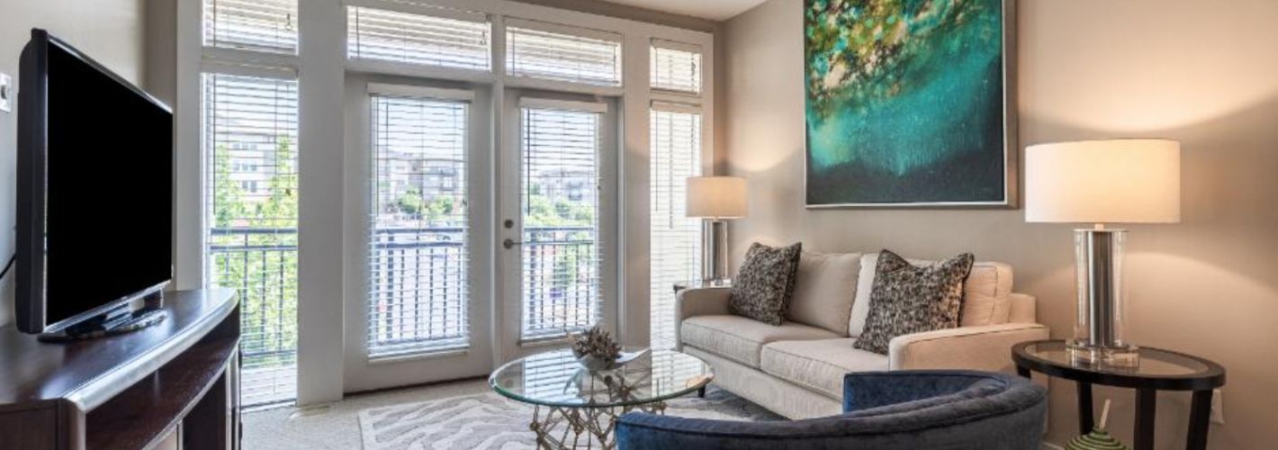 Photo of furnished living room with natural light entering through patio doors
