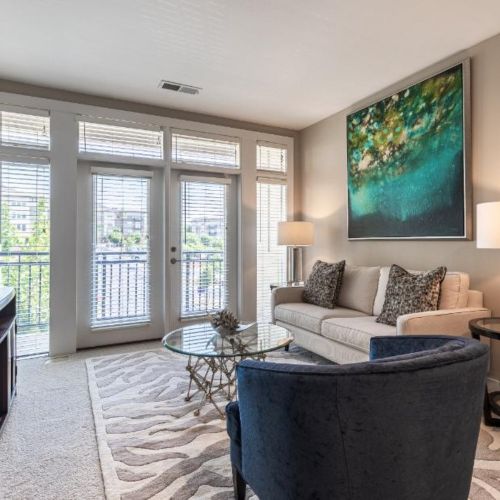 Photo of furnished living room with natural light entering through patio doors