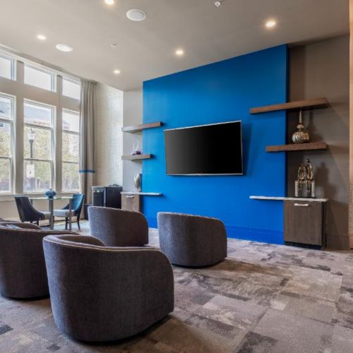 Photo of lounge area with multiple seats facing a mounted tv