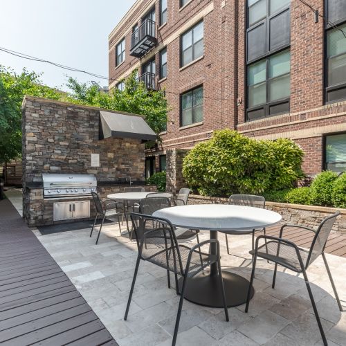 Image showing Outdoor grill station with stainless steel grills and modern seating area.