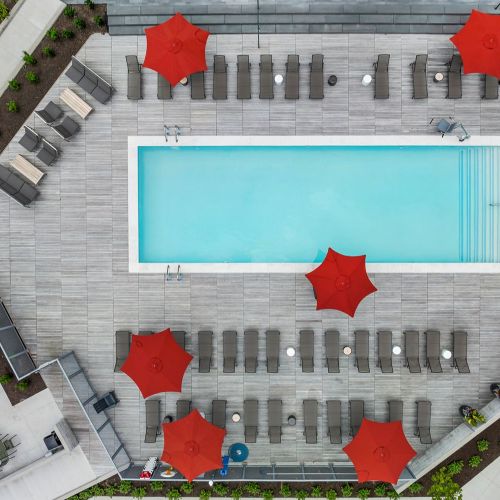 A stunning aerial view of the sparkling outdoor pool and its relaxing surroundings.