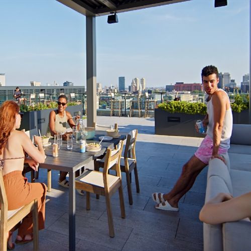 Residents eating by the pool under cabanas.
