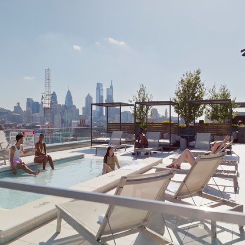 Residents in the rooftop pool with skyline views.