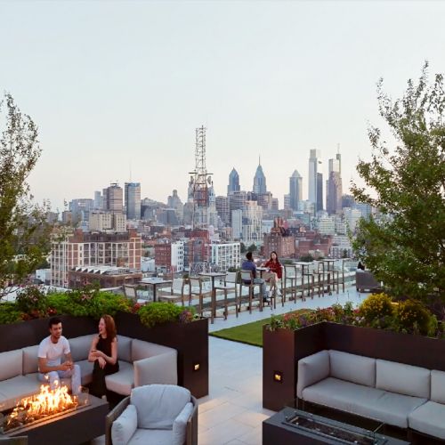 Residents by the rooftop fire pit at sunset.