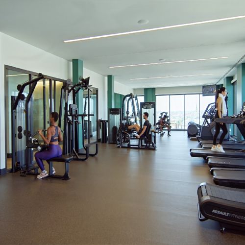 Residents using weight and cardio machines in the fitness center