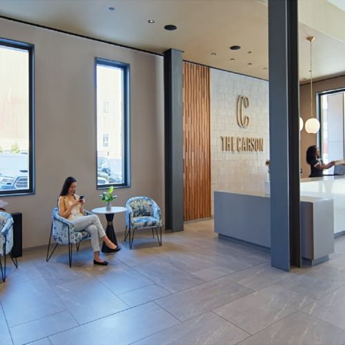 Residents speaking with concierge in spacious lobby