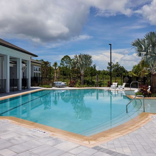 Resort-inspired pool with lounge chairs and clubhouse