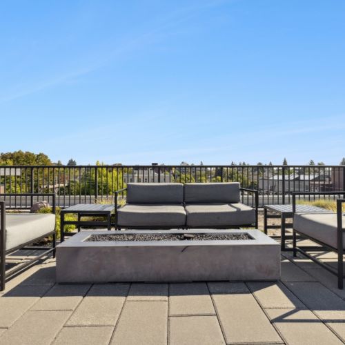 Outdoor firepit lounge on Smith & Burns rooftop overlooking Seattle skyline