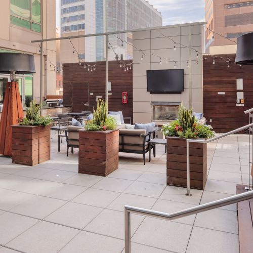 Rooftop lounge with sectional seating and TV.